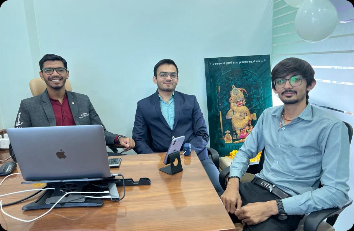 3 person sitting with laptop on table